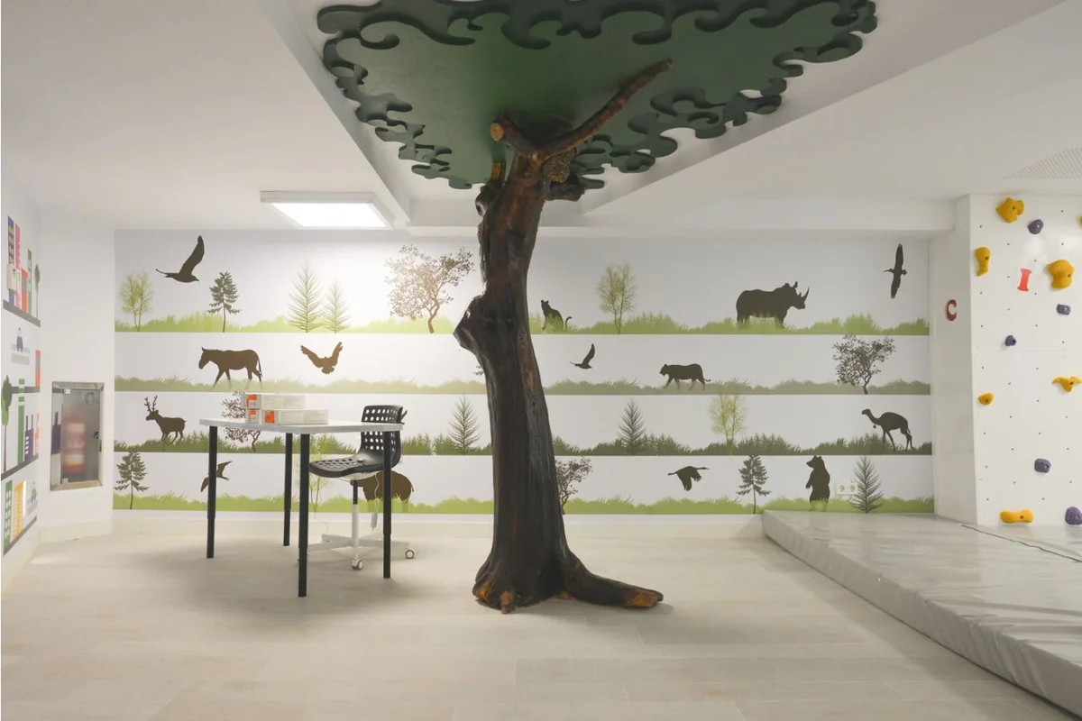 Kids Club del Hotel Puente Romano: árbol escultórico, mural y rocódromo